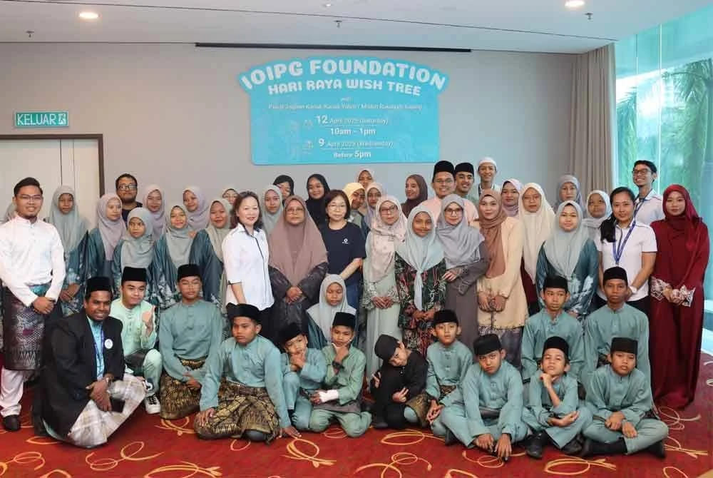 Penjaga dan penghuni Pusat Jagaan Kanak-Kanak Yatim atau Miskin Rukaiyah, Kajang bergambar bersama dalam program Pohon Keinginan Hari Raya Yayasan IOIPG pada Sabtu.