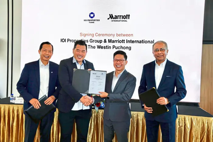 Chong (second from left) and Andree exchanging documents after the signing ceremony. With them are Teh (left) and Varughese. — LOW LAY PHON/The Star